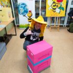Uczeń w kapeluszu pszczelarskim z ulem