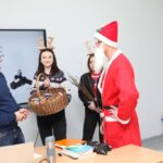 Mikołaj z Uczennicami wręczają słodycze Nauczycielowu