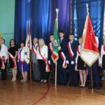 Poczty sztandarowe podczas części oficjalnej na sali sportowej