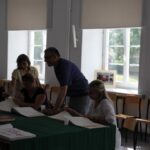 Absolwenci przeglądają kroniki szkolne