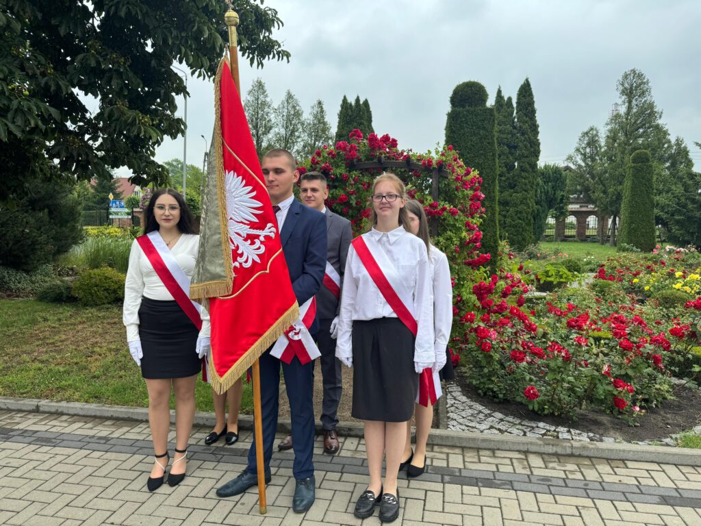 Poczet Sztandarowy przed pomnikiem Patrona