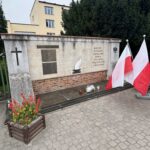 Kwiaty i znicze złożone pod miejscem straceń
