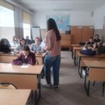 Uczennica Zuzanna Wysocka rozdaje uczniom materiały