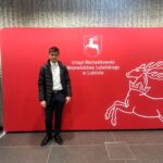 Uczeń ZSCKR na tle planszy Urzędu Marszałkowskiego