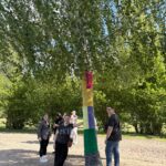 Uczniowie pozują pod ozdobionym drzewem
