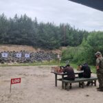 Uczniowie ZSCKR pod okiem instruktora strzelają zza stołu
