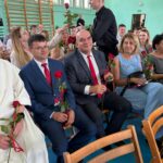 Uczniowie wręczają kwiaty nauczycielom
